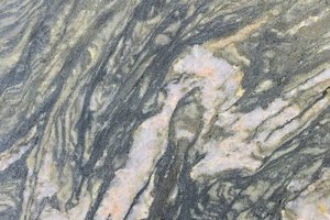 A green granite with sweeping gray and white veining and layered movement.