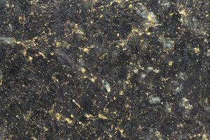 A dark green granite with dense black grain and subtle gold flecks.