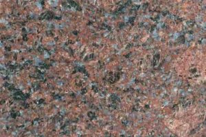 A red granite with fine black and gray speckling in a consistent pattern.