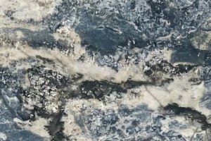 A blue-gray granite with sweeping mineral bands and clustered feldspar crystals.