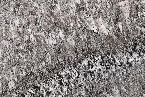 A gray granite with sweeping diagonal movement and bold white mineral clusters.