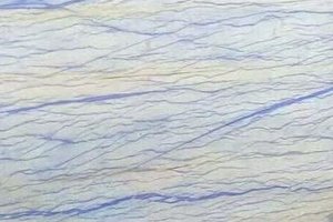 A white and pale blue granite with flowing cobalt veining and layered movement.