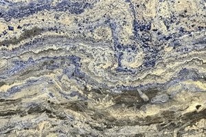 A deep blue granite with flowing layers of navy, charcoal, and warm beige veining.