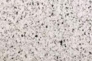 A white granite with grey spots.
