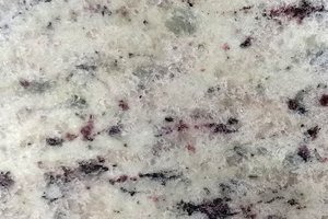 A light cream granite with soft gray movement and subtle dark mineral specks.