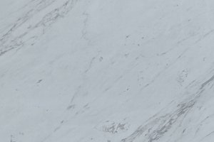 A white marble with soft gray veining and gentle, flowing movement throughout the surface.