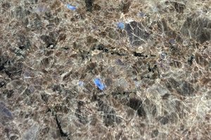 A brown granite with coarse crystalline patterning, and subtle blue reflective flecks