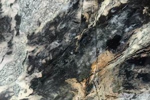 A dark granite with dramatic movement in black, olive, and smoky gray tones.