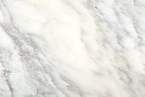 A white marble with soft gray veining and subtle linear movement.