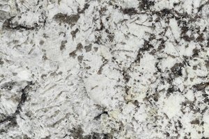 A white granite with bold black crystal formations and scattered dark accents.