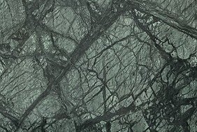 A deep green granite with dense black veining and fractured, crystalline movement.