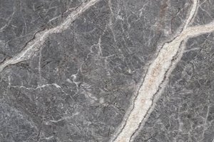 A medium gray marble with bold white veining and fine branching lines.