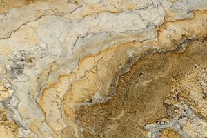 A beige granite with soft, flowing movement and scattered darker mineral speckling.