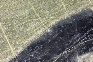 A light yellow and dark green marble with grey veins.