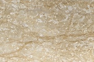 A warm beige marble with fine gold veining and soft tonal variation.
