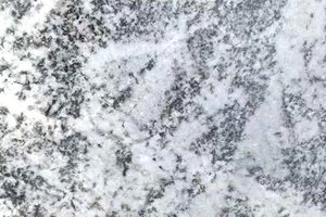 A white granite with soft gray movement and fine black speckling.
