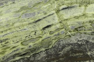 A green onyx with olive bands and gray crystalline patches.