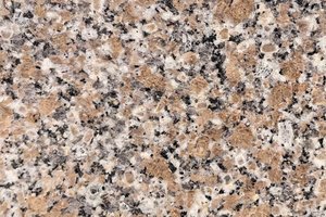 A pink granite with tan crystals and black speckling.