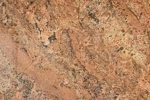 A rust-colored granite with broad mineral swirls and dark mottled flecks.