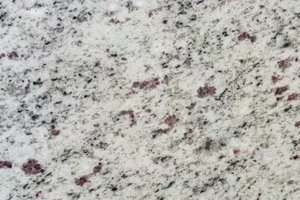 A light gray granite with fine black mineral flecks and scattered burgundy crystals.