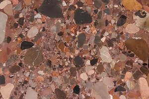 A reddish brown granite with rounded multicolor stone fragments.