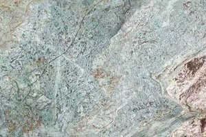 A green granite with sweeping movement and warm brown accents.