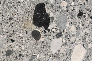 A medium gray granite with a varied pattern of charcoal, gray, and off-white stone fragments.