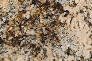 A warm gold granite with layered crystalline clusters and dispersed dark mineral accents.
