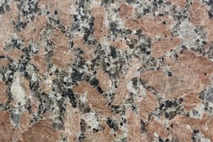 A pink granite with coarse feldspar crystals and black and gray mineral speckling.