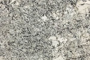 a white granite with beige variation and dense veining of brown and black.