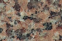 A consistant dark red granite that has brown and black flecks.