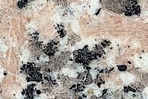 A red and pink granite with a pattern of black and white speckles.